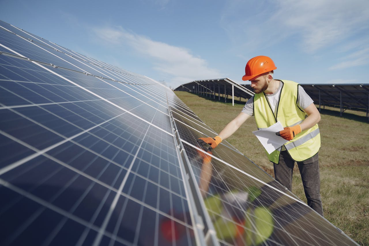 A technician inspecting high-efficiency solar panels at a site supported by yes! invest africa.